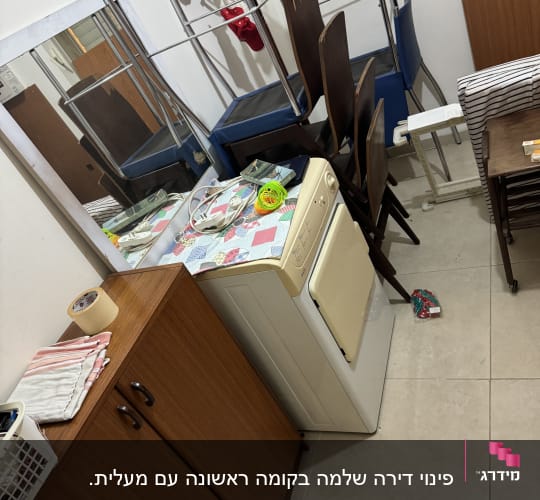 חדר עם מכונת כביסה, ארון עץ, כיסאות ומדפים